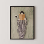 A framed image of a person in a striped outfit reading a book.