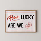A framed poster with the text "How LUCKY ARE WE" and two dice graphics.