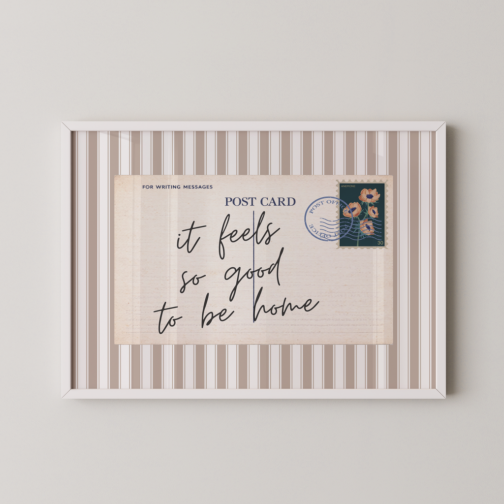 The image is a framed postcard with a handwritten message that reads "it feels so good to be home".