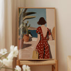 a woman in a red polka dot dress standing in front of a window, looking out at the ocean.