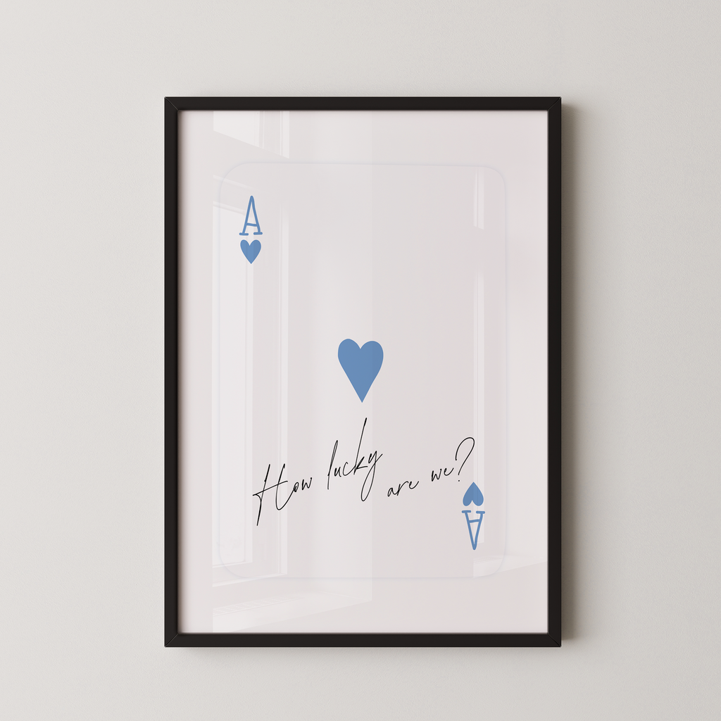The image is a framed print with a white background and a black border. It features a blue heart symbol and the text "How lucky are we?" written in a cursive font.