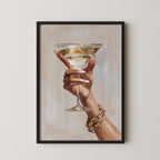 A framed painting depicting a hand holding a martini glass.