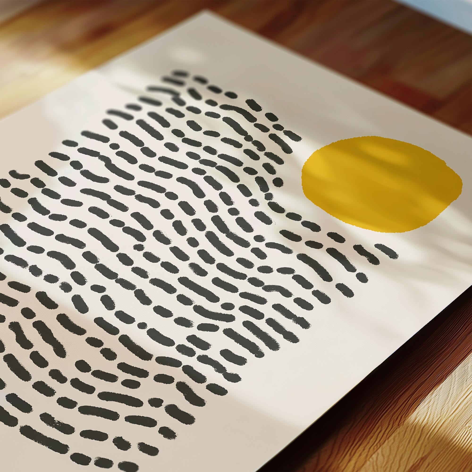 a close-up view of a piece of paper with a black and white abstract pattern, including a large yellow circle in the center.