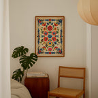a cozy corner of a room with a wooden chair, a wooden side table, and a framed floral print hanging on the wall.
