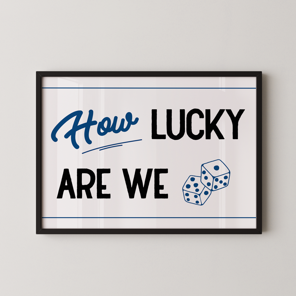 A framed poster with the text "How LUCKY ARE WE" and two dice graphics.
