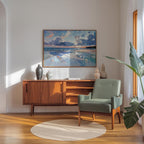 a cozy living room with a wooden cabinet, a green armchair, and a large painting of a serene landscape hanging on the wall.