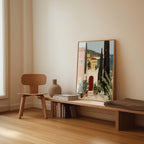 a wooden chair, a wooden bench, a vase, and a framed painting of a coastal town scene.