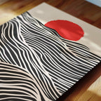 a striking abstract artwork with bold black and white stripes and a large red circle in the center.