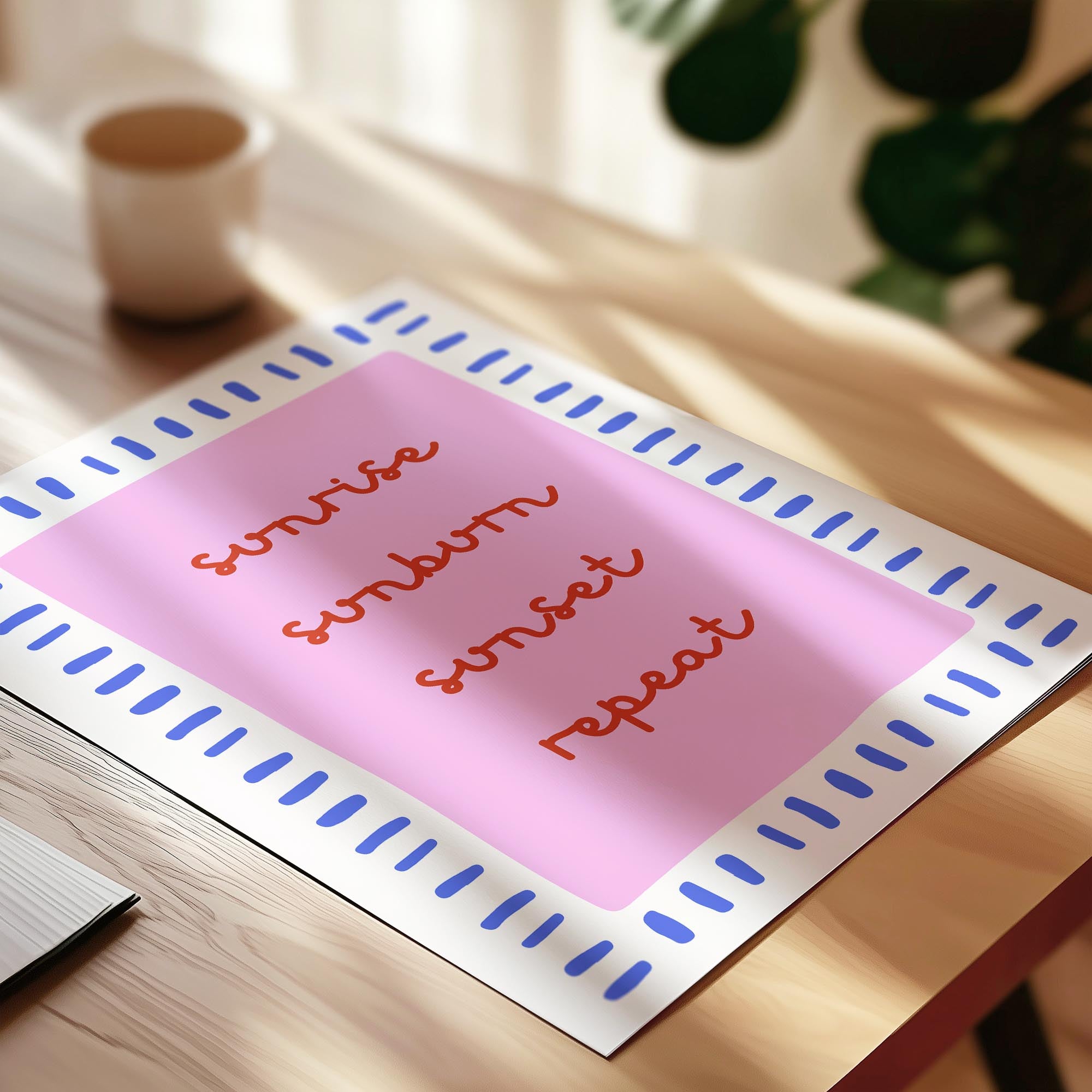 A pink poster with blue borders and the words "Sunrise, Sunrise, Sunset, Sunset, Repeat" written in red cursive font.