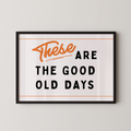 a framed poster with the text "These are the good old days" in a bold, orange font.