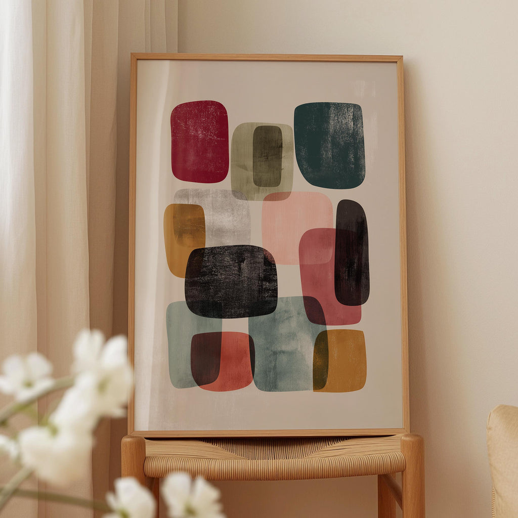 a framed abstract art piece with various colored shapes and forms, displayed on a wooden stand.