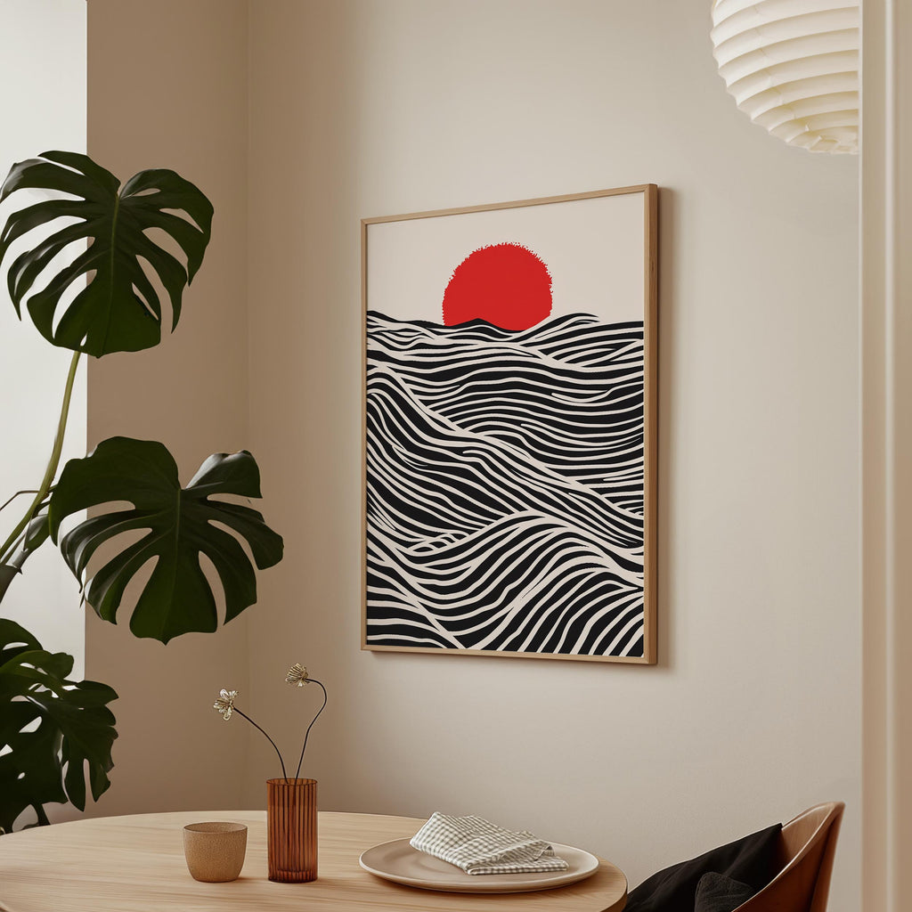 a minimalist dining area with a wooden table, a vase with flowers, and a framed artwork depicting a red sun on a black and white wave-like background.