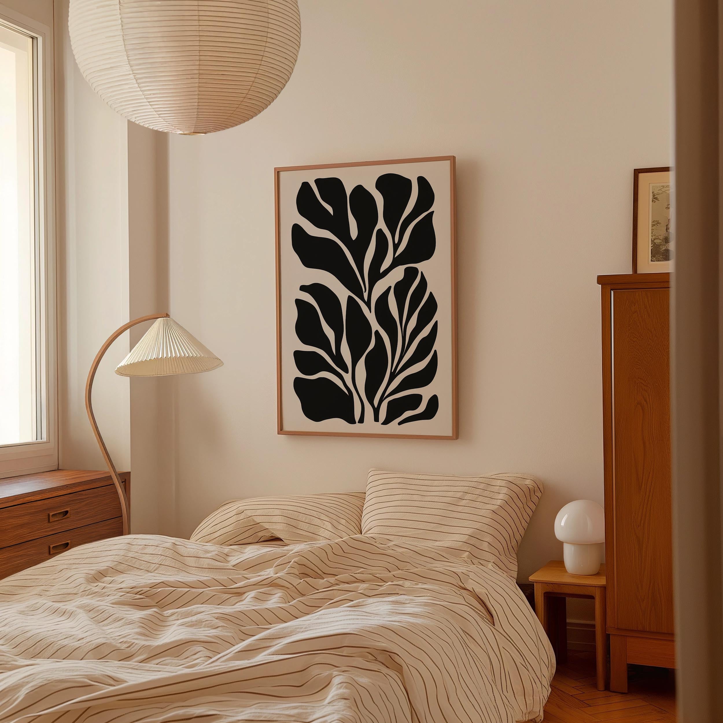 a bedroom with a bed, a lamp, and a framed artwork on the wall.