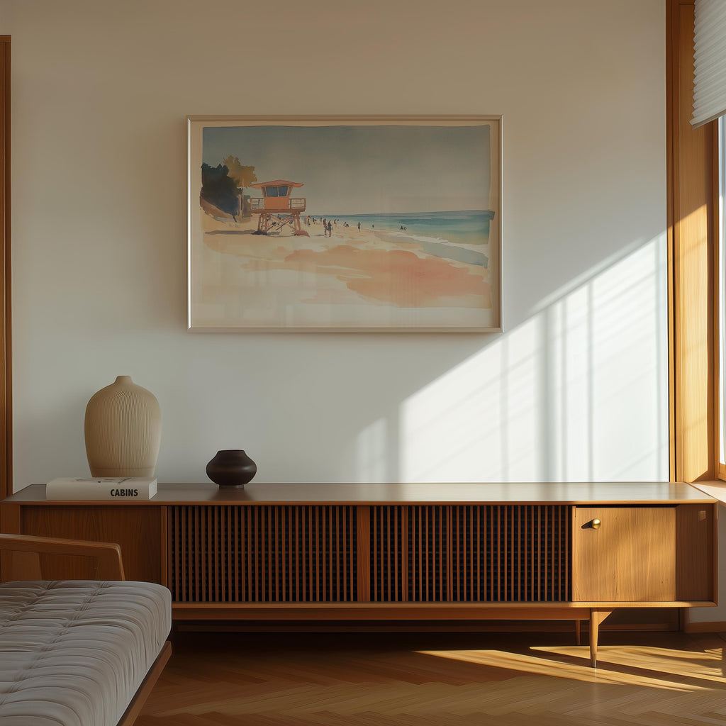 a serene beach scene with a lifeguard tower, a vase, and a book on a wooden cabinet.