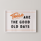 a framed poster with the text "These are the good old days" in a bold, orange font.