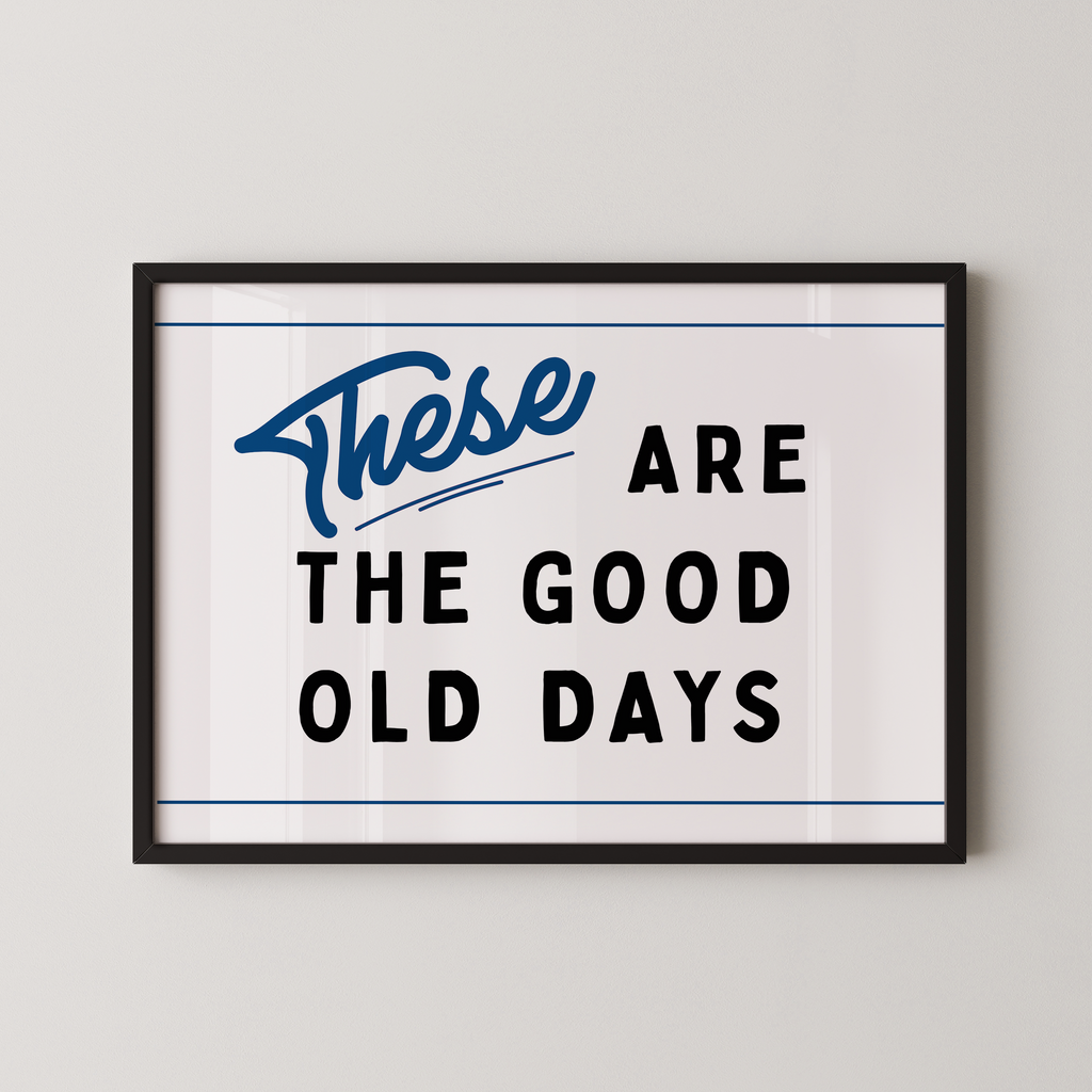 a framed poster with the text "These are the good old days" in a blue cursive font.