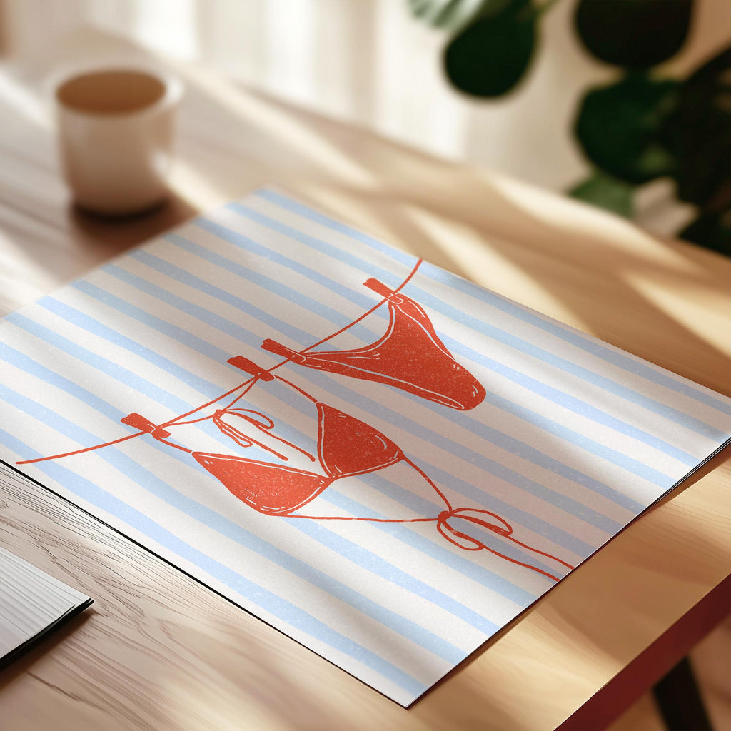 A printed image of a pair of red bikini bottoms hanging on a clothesline on a striped background.