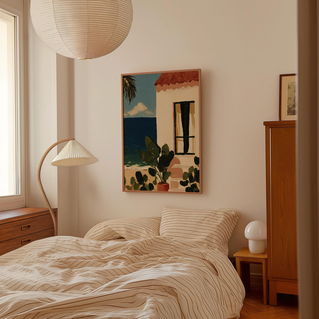 a cozy bedroom with a large bed, a wooden dresser, and a lamp. A framed painting of a house with a palm tree is hanging on the wall above the bed.