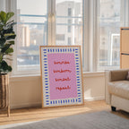 a poster with the text "sunrise, sunset, repeat" in a pink and blue frame, placed in a living room near a window.