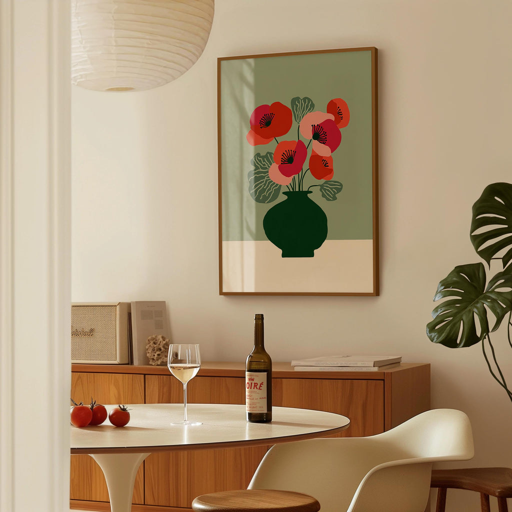a dining room with a table, a wine bottle, a wine glass, and a framed picture of red flowers on the wall.
