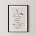 a framed poster with a cartoon illustration of a woman relaxing in a cup of coffee, accompanied by the text "Coffee tastes better when you slow down".