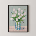 A framed painting depicting a vase filled with white tulips, surrounded by butterflies on a pink and white checkered tablecloth.