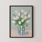 A framed painting depicting a vase filled with white tulips, surrounded by butterflies on a pink and white checkered tablecloth.
