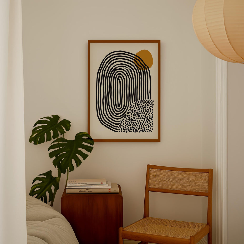 a minimalist interior design with a framed abstract artwork hanging on the wall, a wooden chair, a stack of books, and a potted plant.