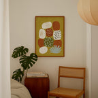 a cozy corner of a room with a wooden chair, a wooden side table, and a framed abstract painting hanging on the wall.