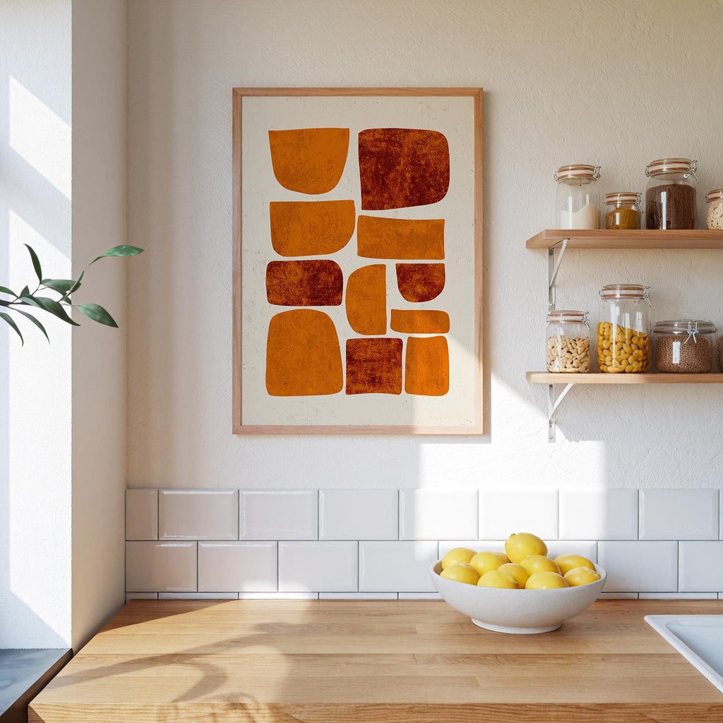 a kitchen counter with a bowl of lemons, a framed abstract art piece, and shelves displaying various jars and containers.
