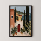 The image is a framed painting depicting a coastal town with colorful buildings, a red door, and lush greenery, including palm trees and potted plants.