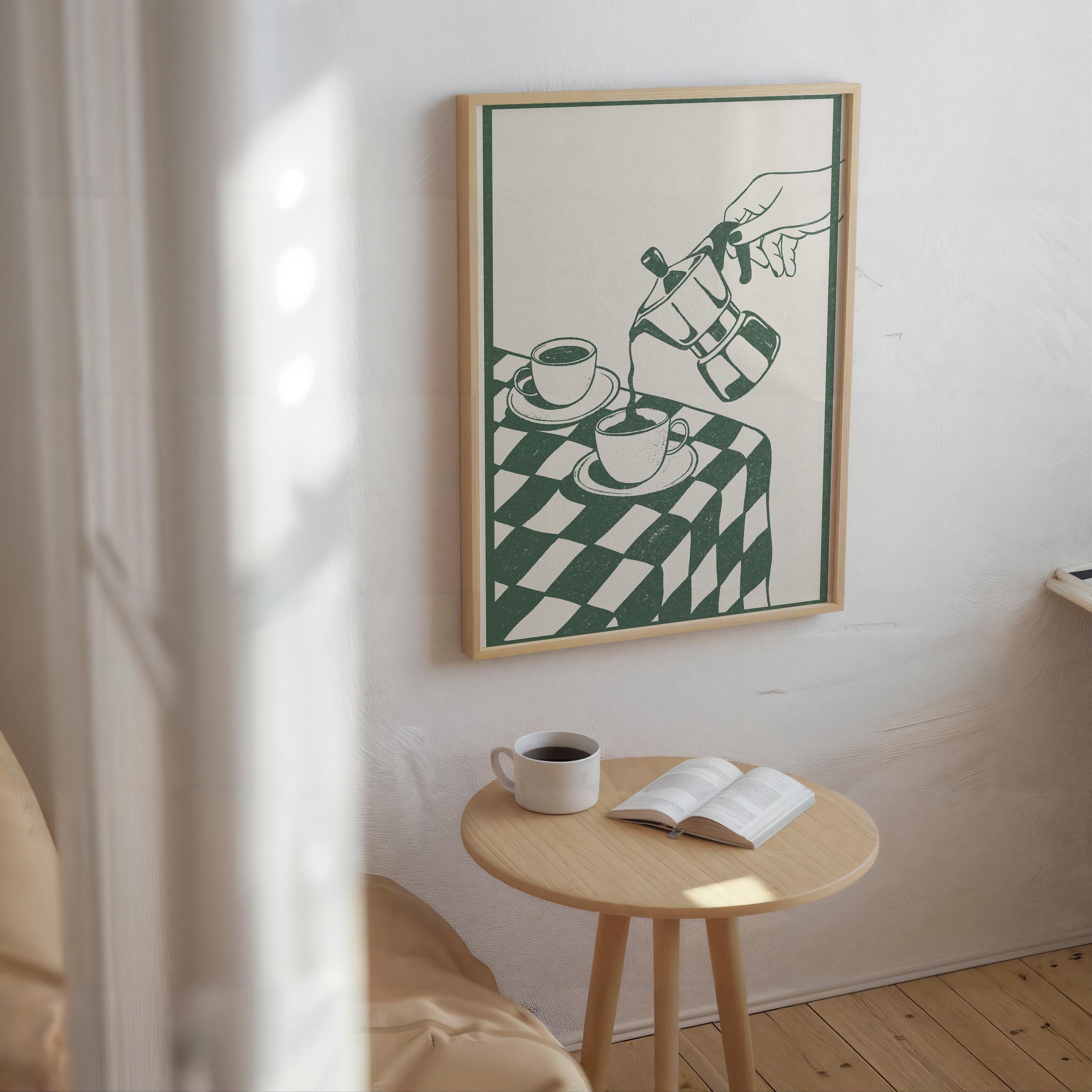 a cozy corner of a room with a wooden table, a white mug, and an open book, all set against a white wall with a framed illustration of a hand pouring coffee.
