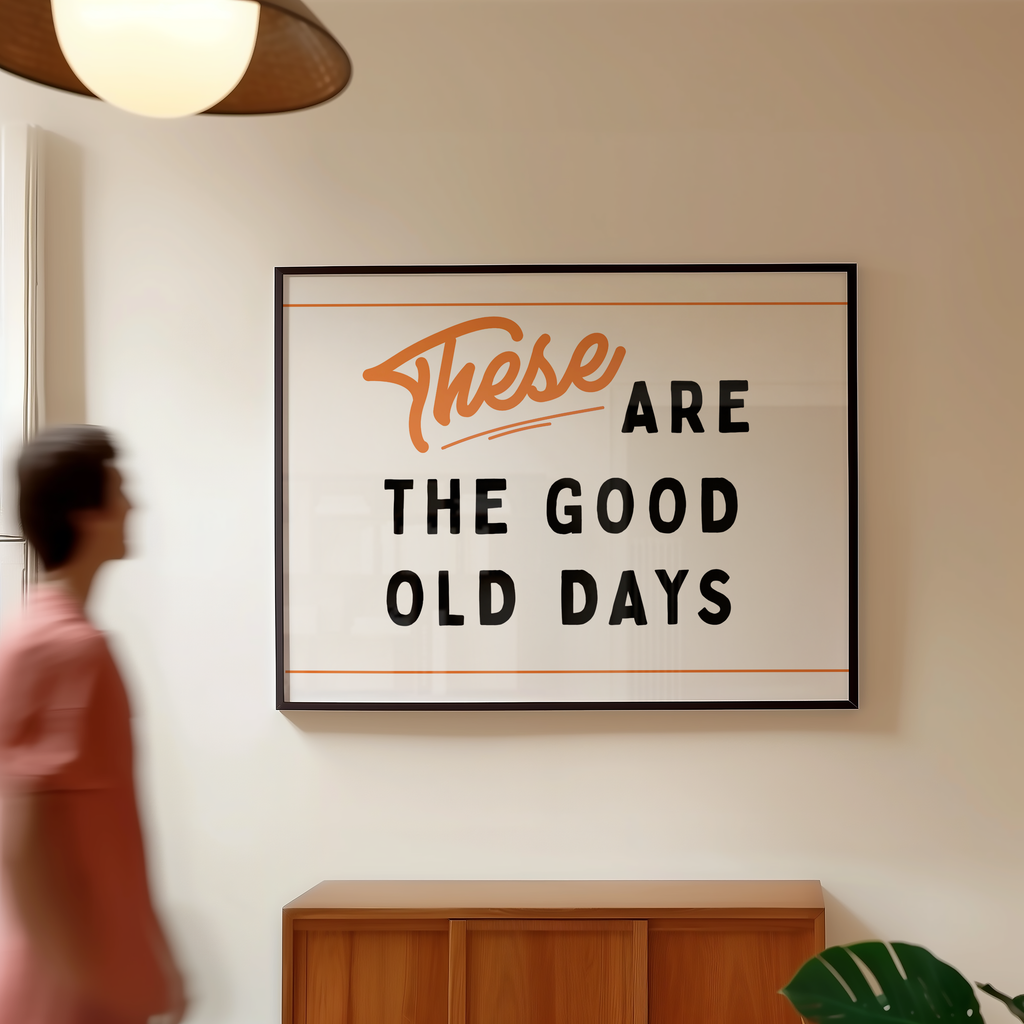 a framed sign with the text "These are the good old days" hanging on a wall.