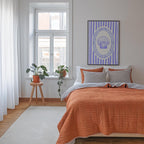 a cozy bedroom with a large bed, a window with a plant on the sill, and a framed artwork featuring a shell design on the wall.
