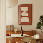 a dining room with a table set for two, a bottle of wine, and a framed abstract artwork on the wall.