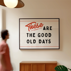 a framed sign with the text "These are the good old days" hanging on a wall.