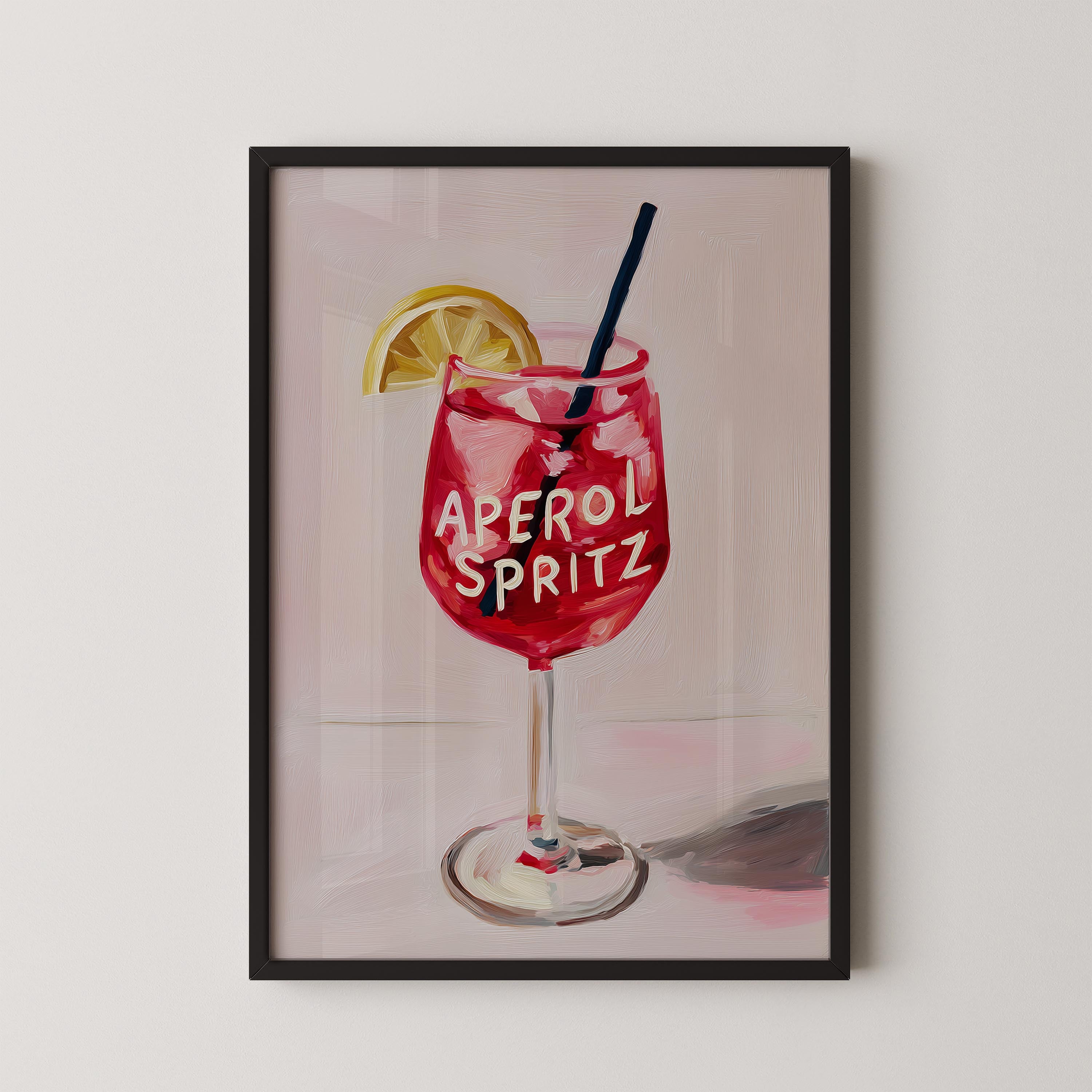 A framed illustration of a red drink with the text "Aperol Spritz" on it, accompanied by a lemon slice.