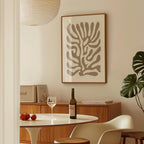 a dining area with a table, a bottle of wine, and a framed abstract art piece on the wall.