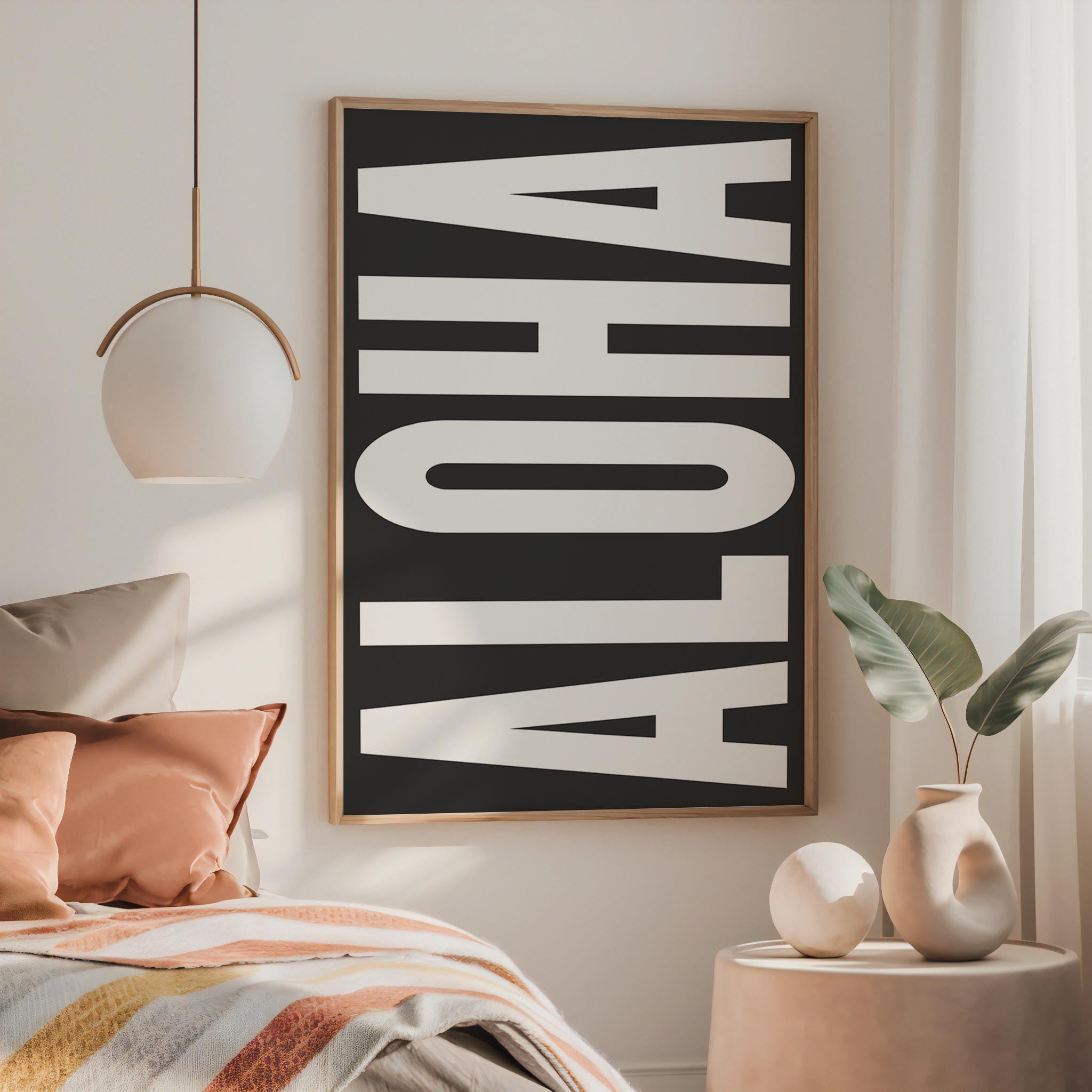 a bedroom with a large framed poster of the word "ALOHA" on the wall, a bed with colorful pillows, and a small side table with a vase and plant.
