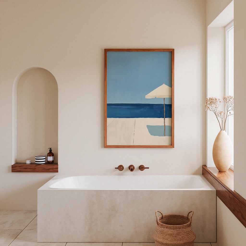 a serene and modern bathroom with a large framed painting of a beach scene above a white bathtub. The painting features a blue sky, a white beach, and a white umbrella. The bathroom also includes a wooden shelf, a vase with flowers, and a basket on the floor.