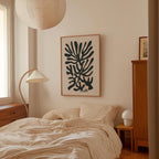 a bedroom with a bed, a lamp, and a framed abstract art piece on the wall.