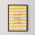 a framed poster with a yellow and white striped background and the text "good vibes only" written in pink cursive font.