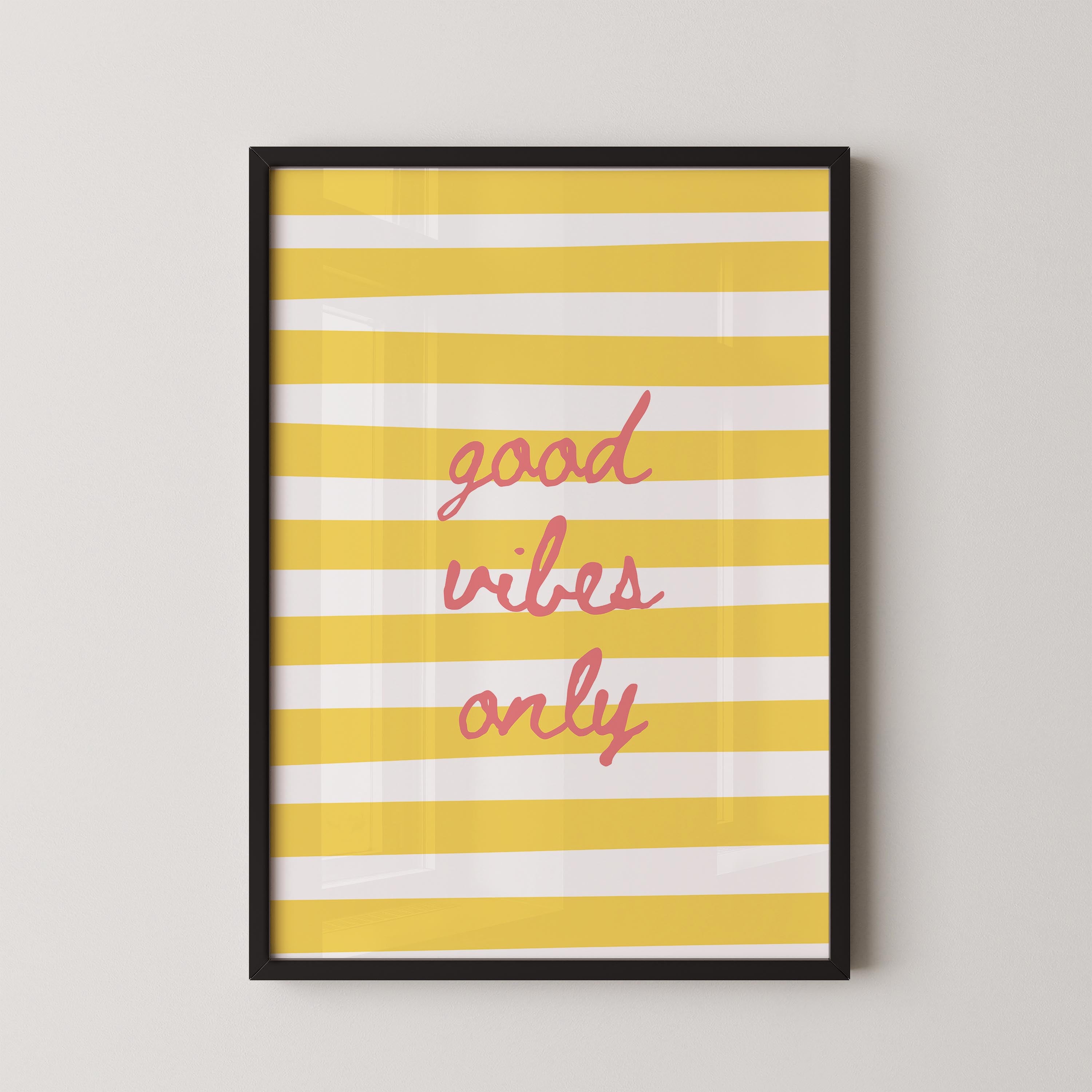 a framed poster with a yellow and white striped background and the text "good vibes only" written in pink cursive font.