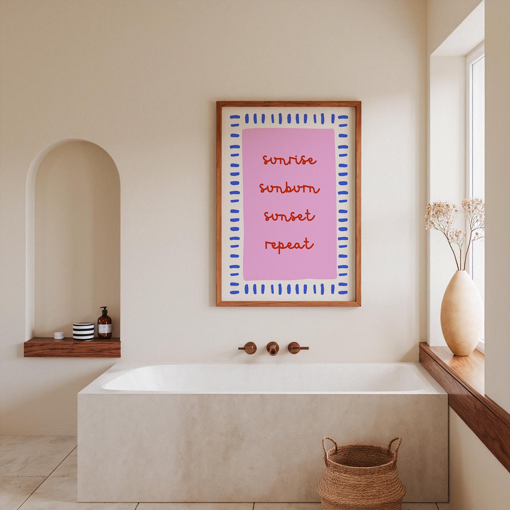 a bathroom with a white bathtub, a framed quote on the wall, and a vase of flowers on the windowsill.