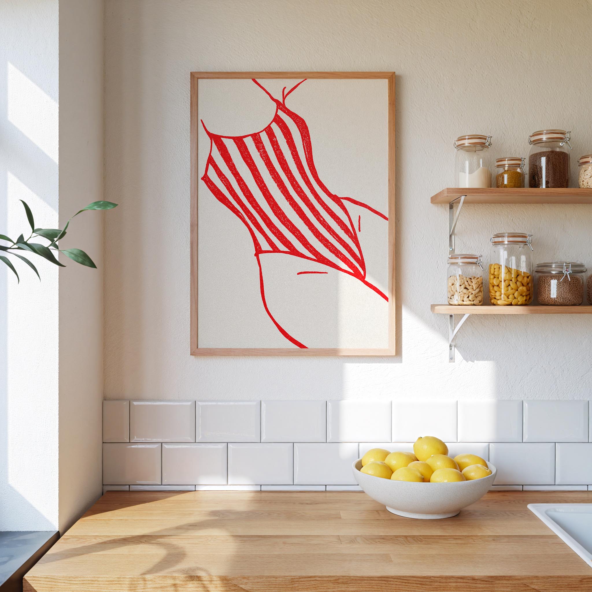 a kitchen counter with a bowl of lemons, a framed artwork of a red and white striped swimsuit, and shelves displaying various jars and containers.