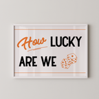 a framed poster with the text "How LUCKY ARE WE" and two dice graphics.
