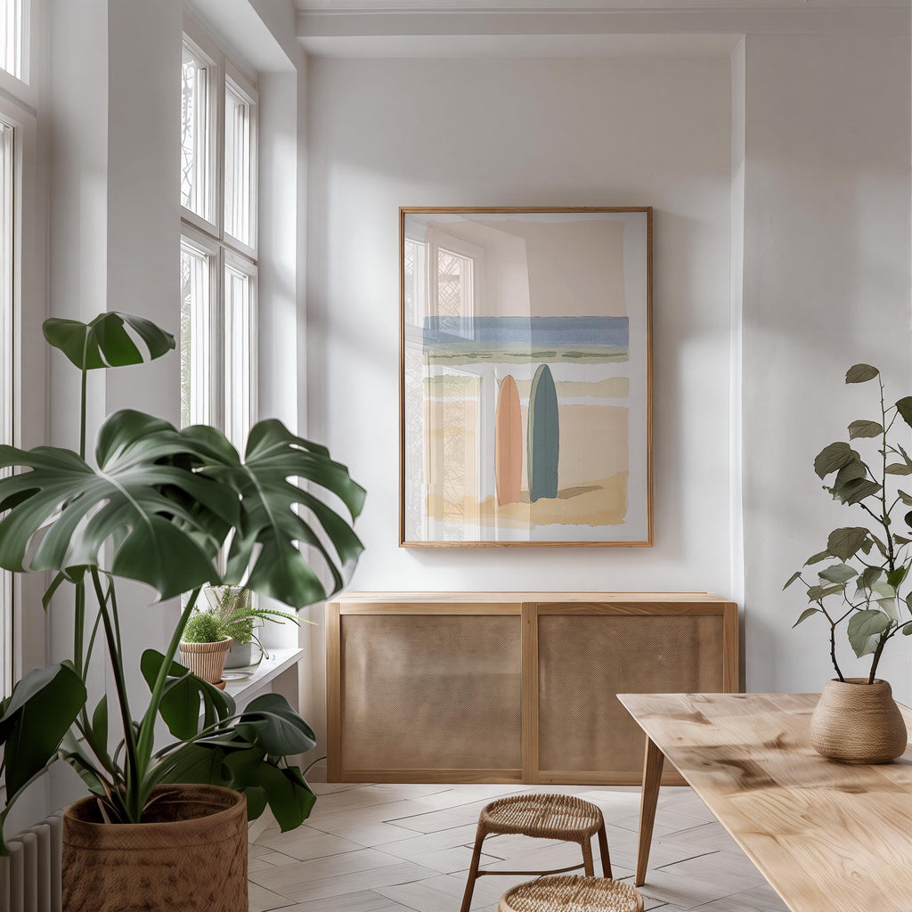 a bright and airy living room with a large window, a wooden cabinet, and a framed artwork of two surfboards on the wall.