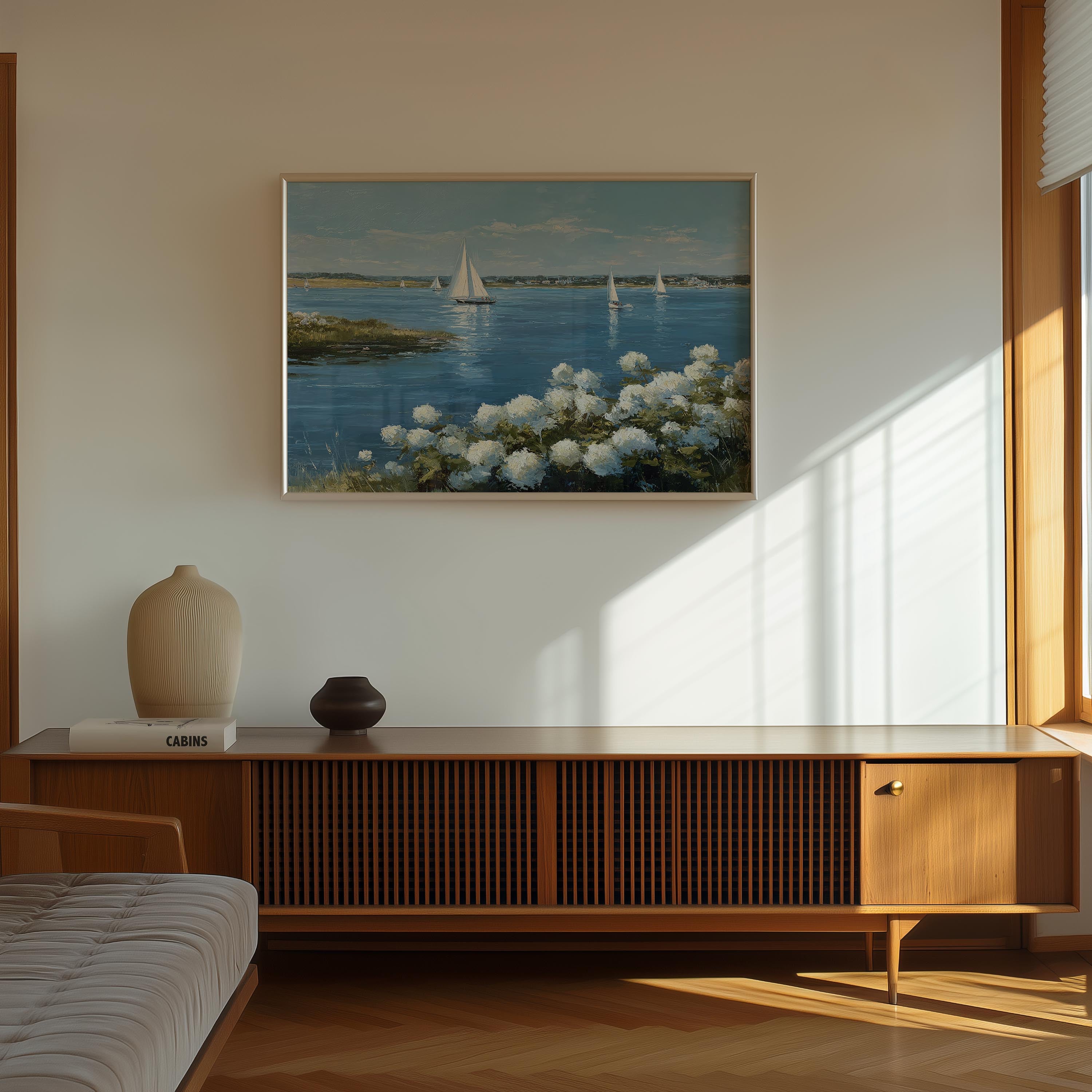 a serene indoor setting with a wooden cabinet, a vase, and a book on a shelf. Above the shelf, there is a framed painting depicting a tranquil scene of sailboats on a body of water, surrounded by white flowers.