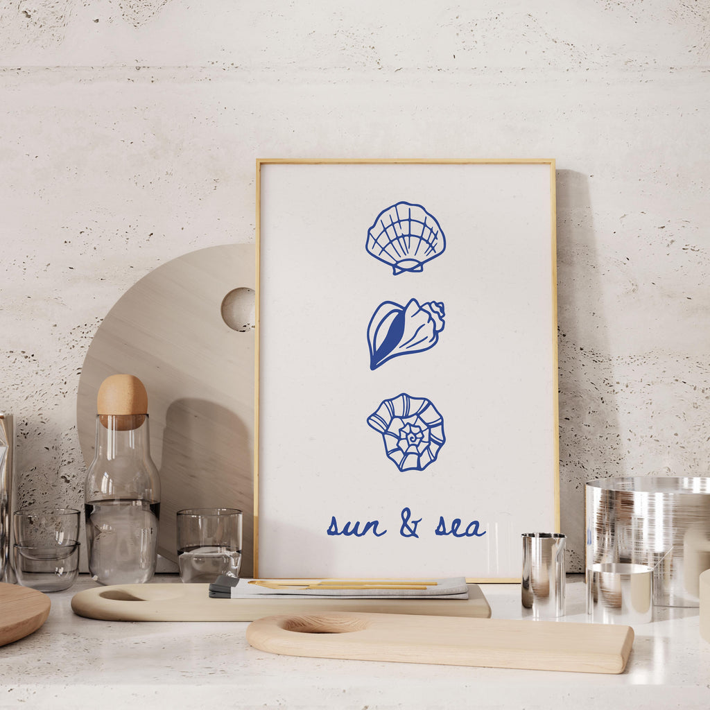 a framed artwork with illustrations of seashells and a blue and white color scheme, placed on a shelf or counter.