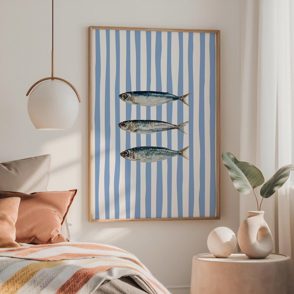 a bedroom with a bed, a framed picture of three fish, and a pendant light hanging above the bed.
